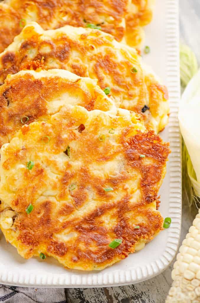 sweet corn fritters topped with chives on platter