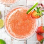 frozen strawberry daiquiri on glass with lime wedge