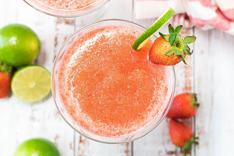 frozen strawberry daiquiri on glass with lime wedge