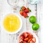 limeade, strawberries, ice, water and limes on table