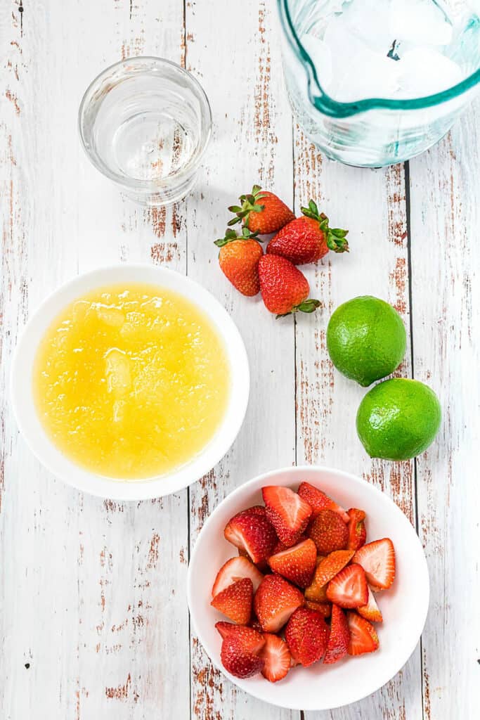 limeade, strawberries, ice, water and limes on table