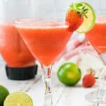 frozen strawberry daiquiri in glass by pitcher