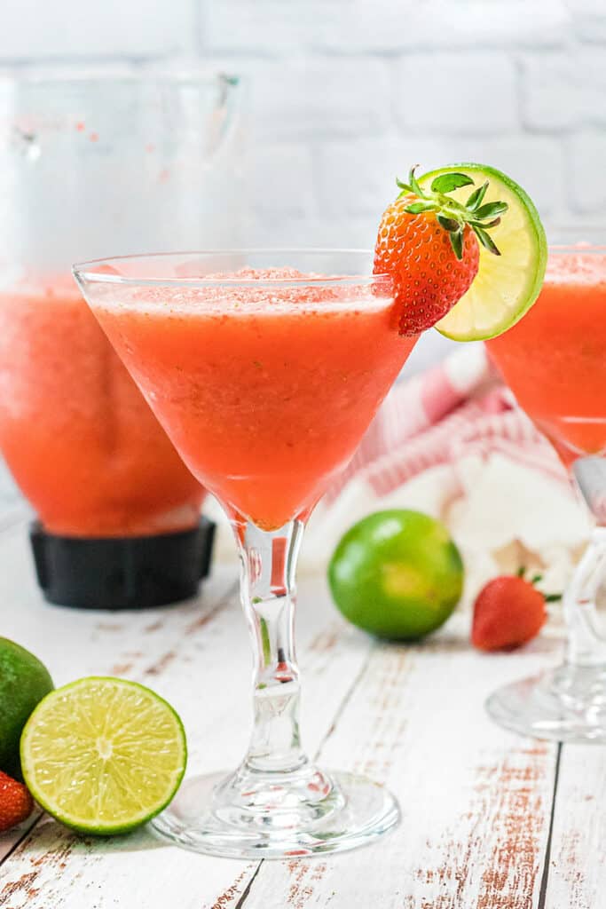 frozen strawberry daiquiri in glass by pitcher