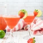 frozen daiquiris on table with limes and fresh strawberries