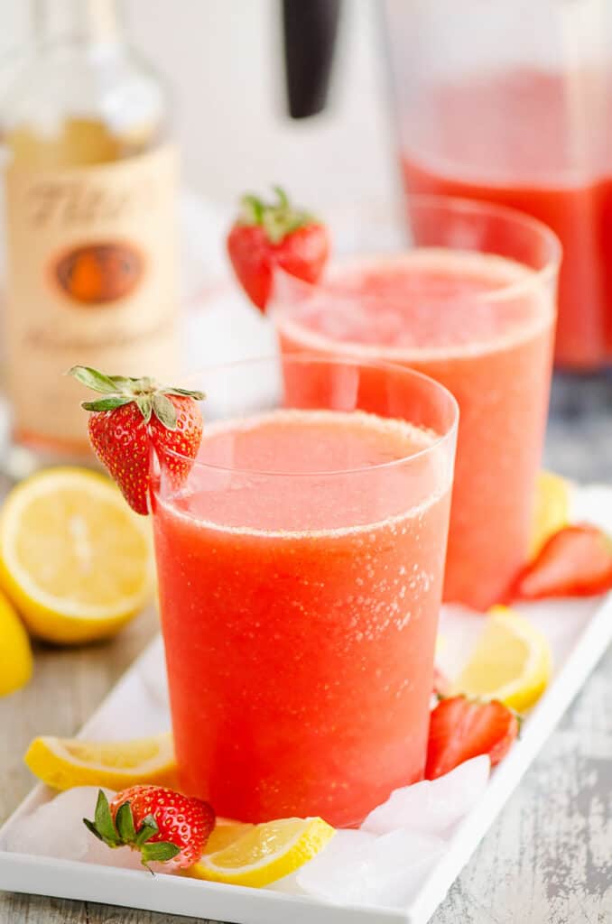 glass of frozen strawberry vodka lemonade on tray of ice