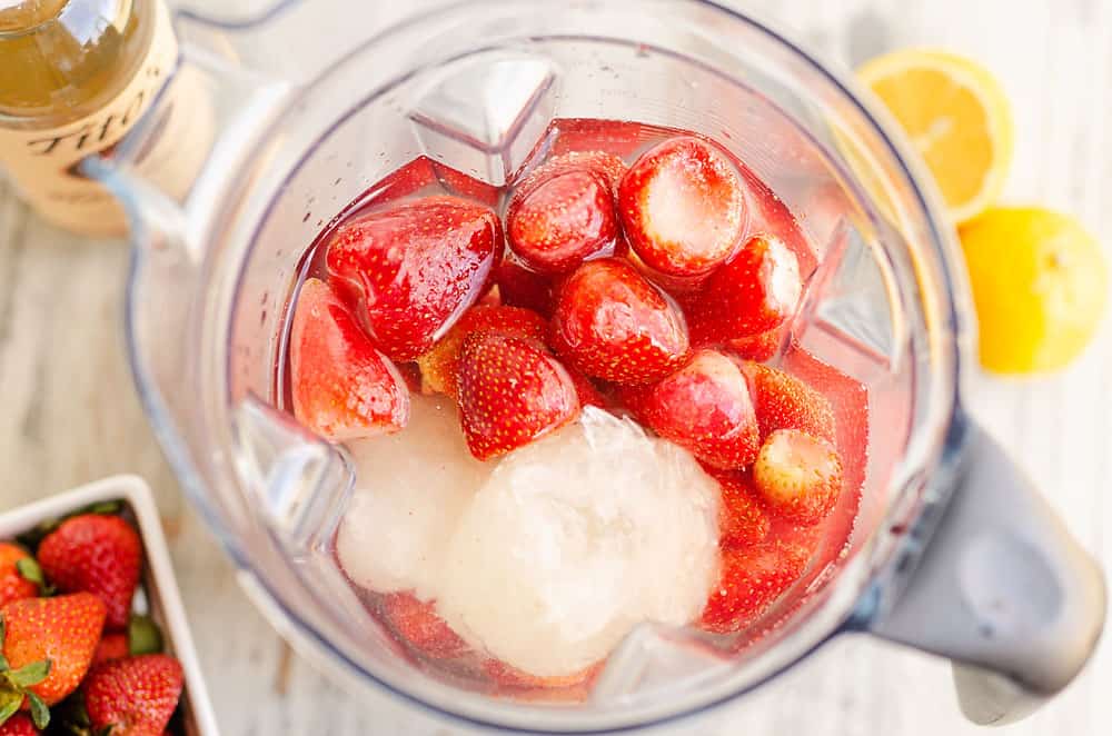 blender filled with lemonade concentrate and strawberries