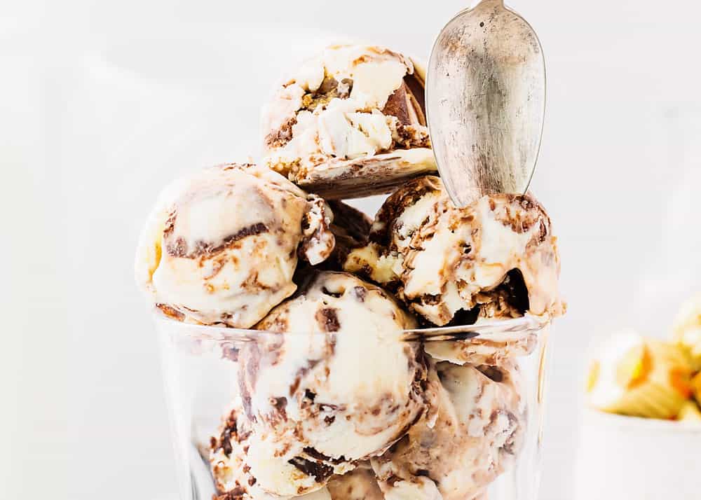 scoops of Moose Tracks ice cream in a glass scooped with spoon