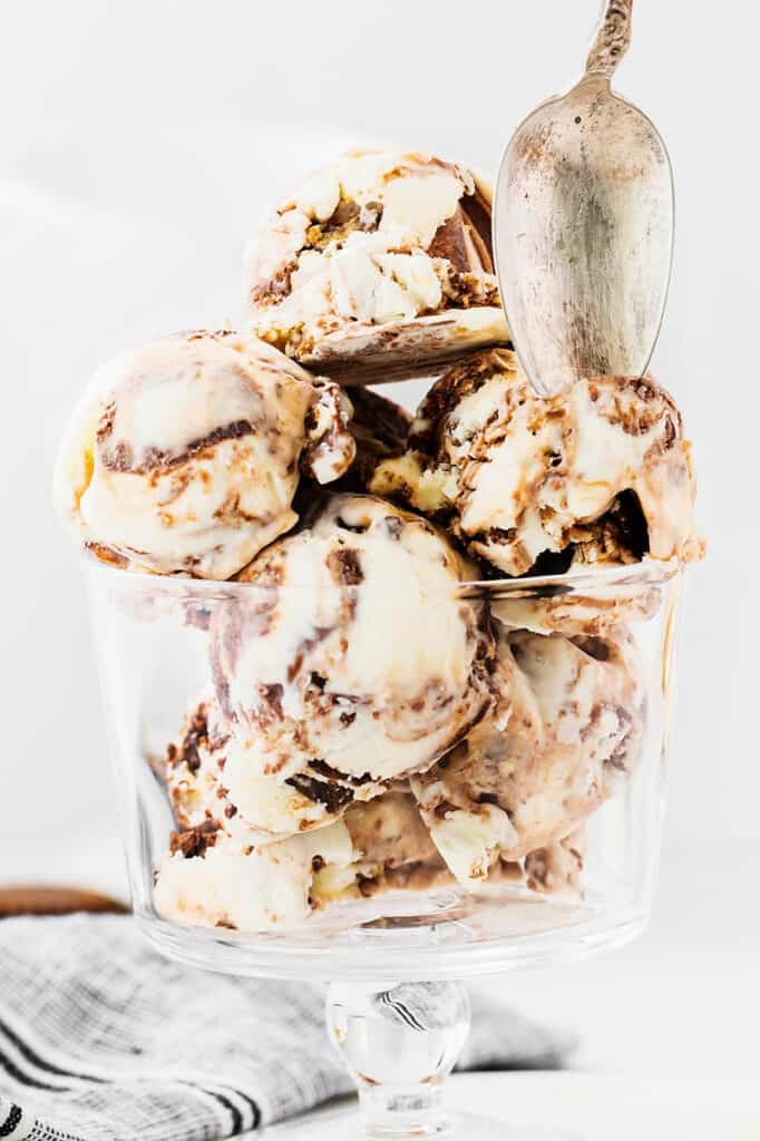 spoon scooping moose tracks ice cream from glass bowl