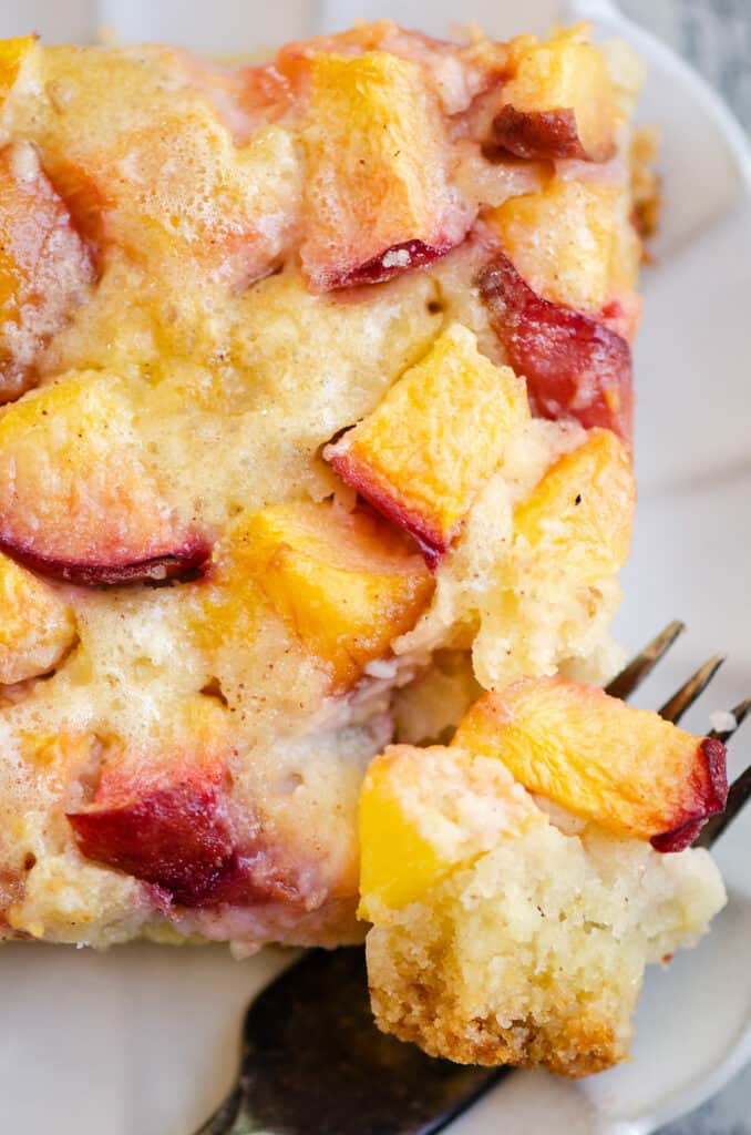 slice of peach custard dessert on plate with fork