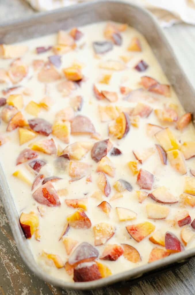 peaches topped with custard in pan