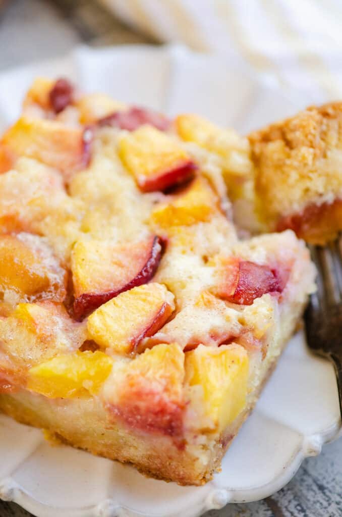 slice of peach custard on plate with bite on fork