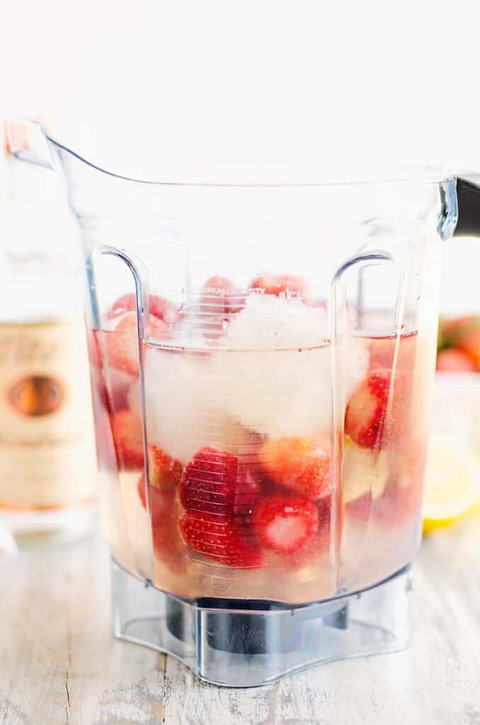 blender filled with lemonade concentrate and strawberries