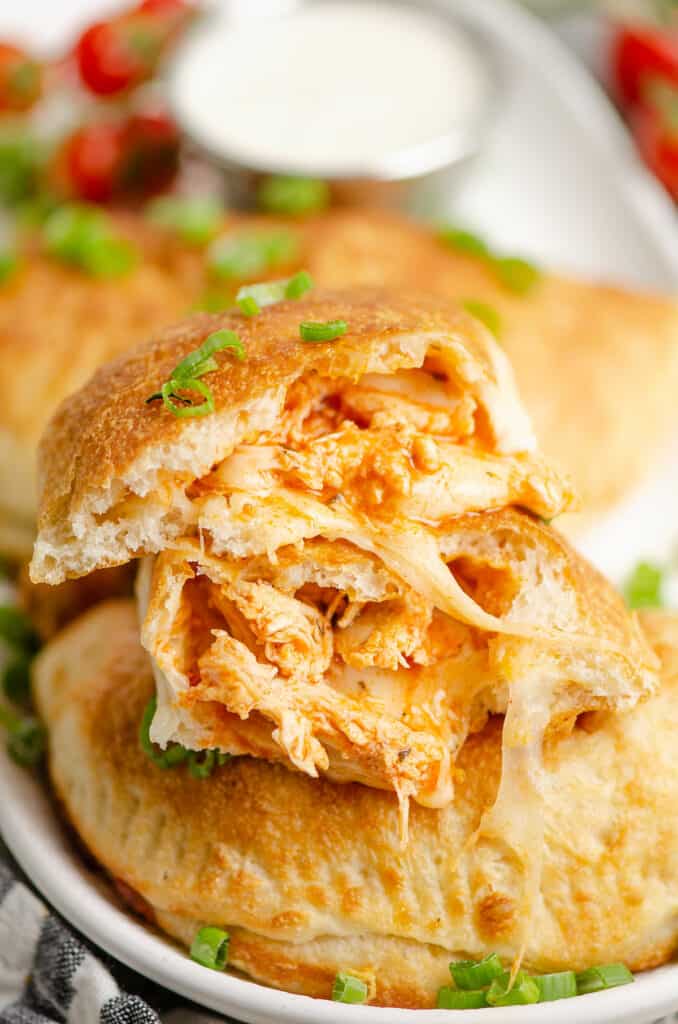 buffalo chicken calzones on platter with one split in half