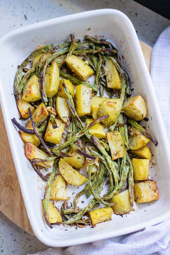 roasted green beans and potatoes in white baking dish