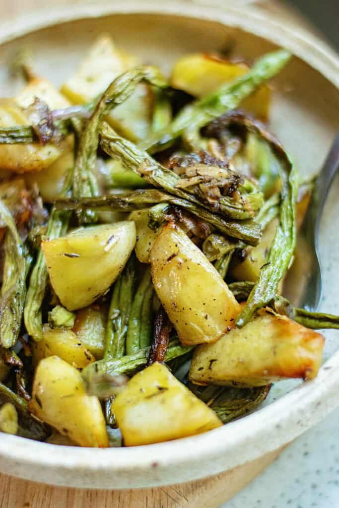 roasted green beans and potatoes on plate with fork