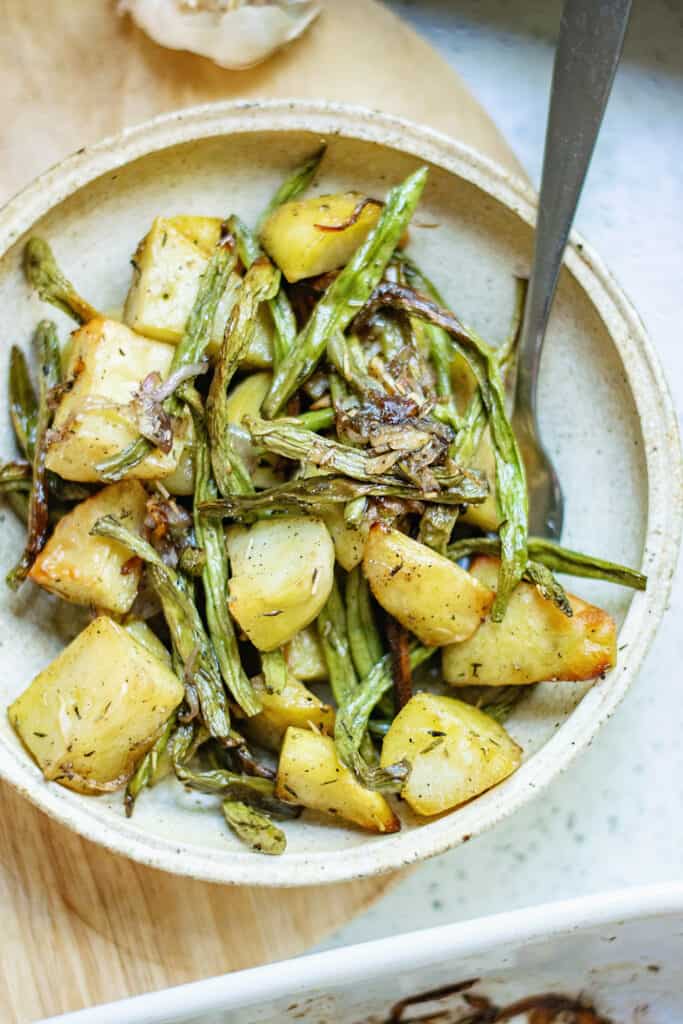 roasted green beans and potatoes on plate with fork