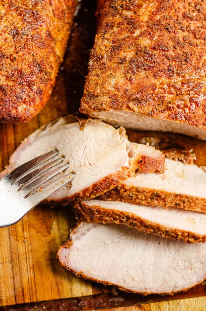 serving fork in slice of pork loin