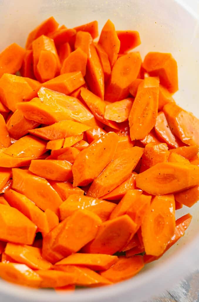 carrots in bowl tossed with olive oil and honey