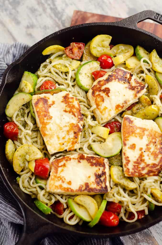 grilled halloumi cheese and pesto vegetable pasta in cast iron pan