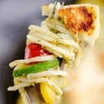 grilled halloumi cheese and vegetable pasta on fork