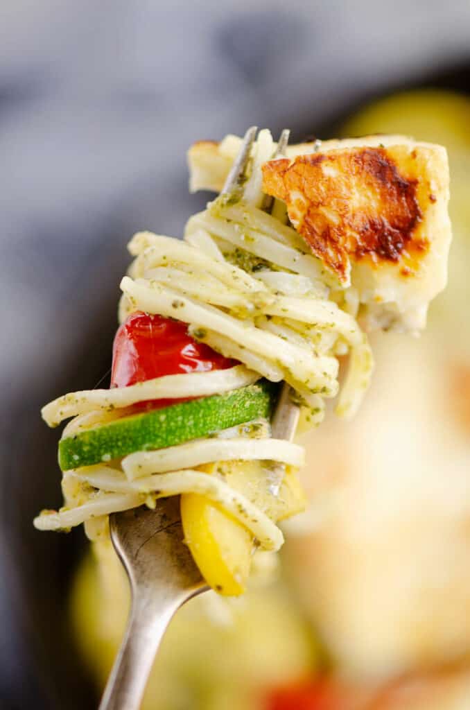 grilled halloumi cheese and vegetable pasta on fork