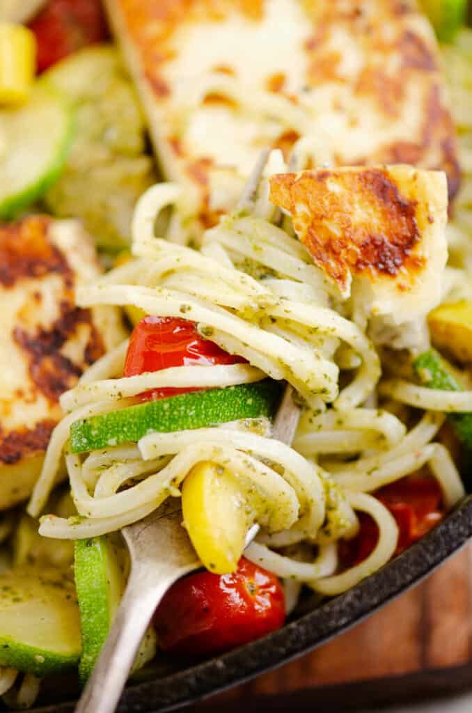 grilled halloumi cheese and vegetable pasta on fork