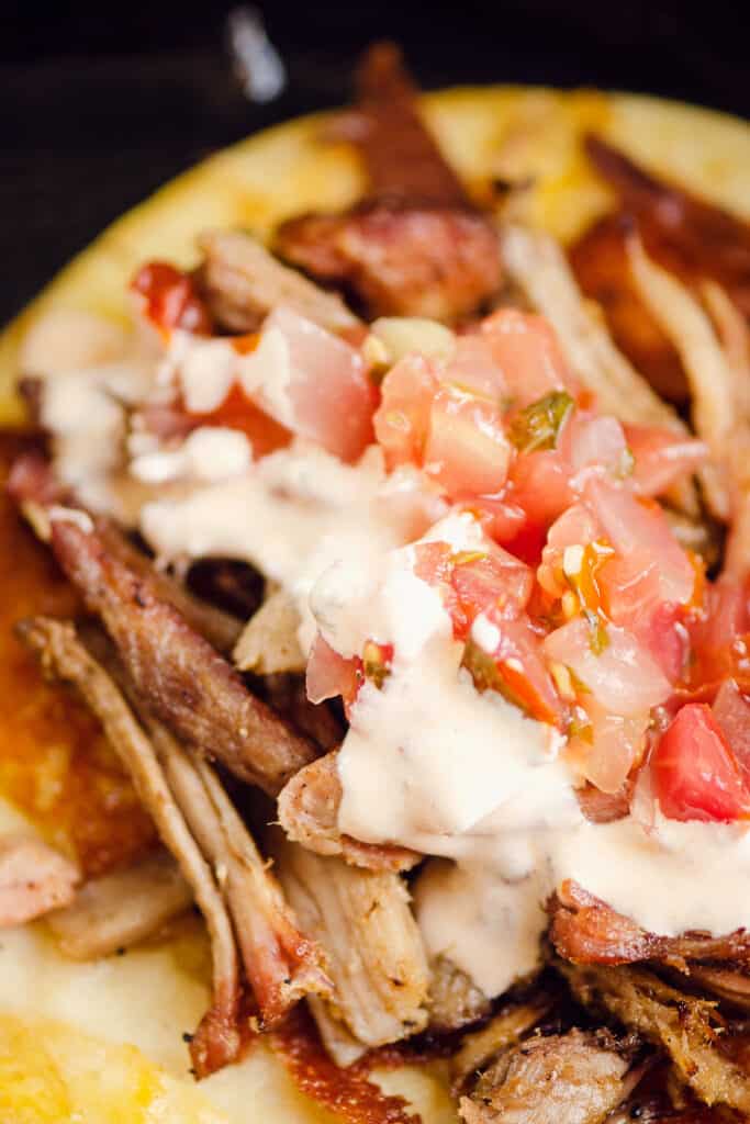 chipotle lime sour cream and pico de gallo on pork carnitas taco