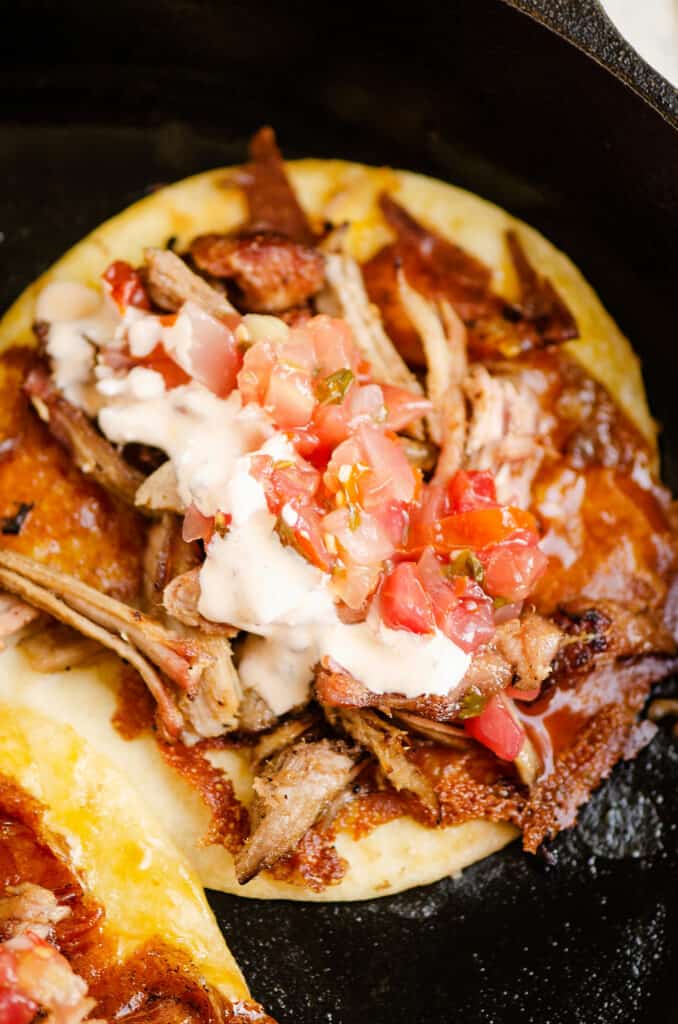 pork carnitas taco with crispy cheese in cast iron skillet