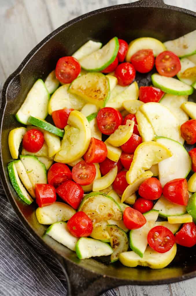 sautéed squash and tomatoes in cast iron pan