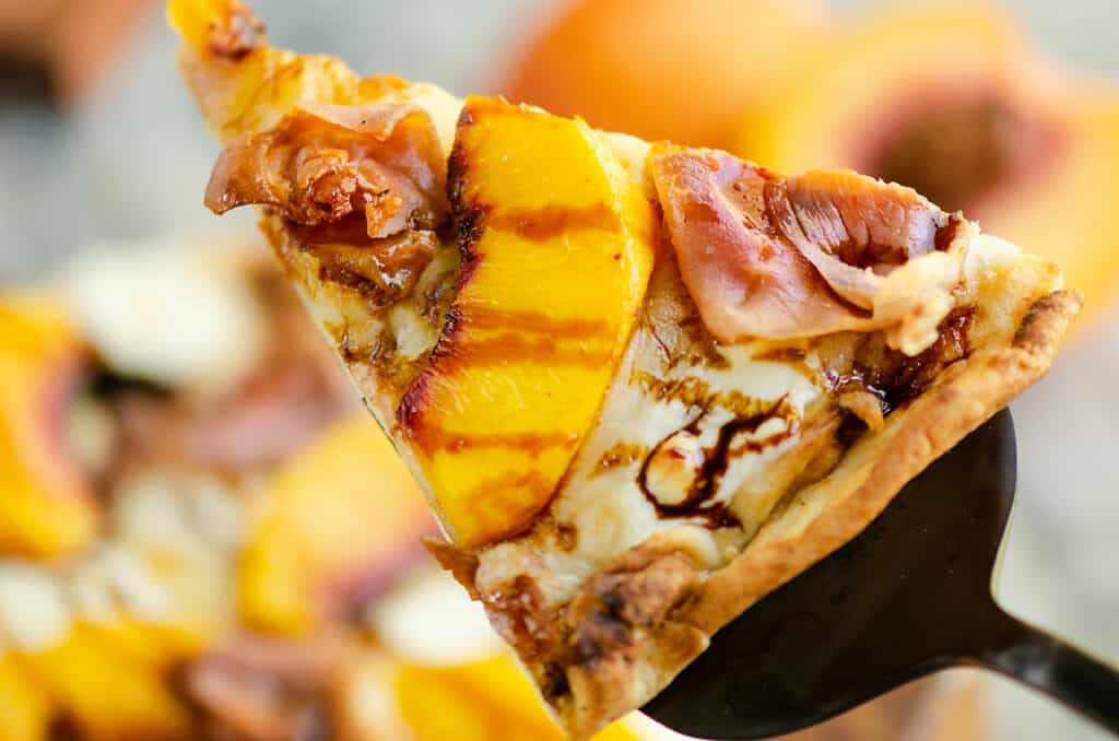 slice of crispy peach and prosciutto pizza