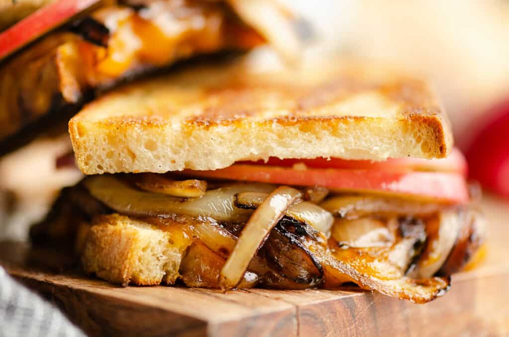 Grilled cheese with apples and balsamic onions on cutting board