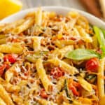 Pasta Primavera in white bowl with fresh basil, lemon and parmesan