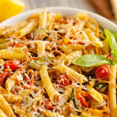 Pasta Primavera in white bowl with fresh basil, lemon and parmesan