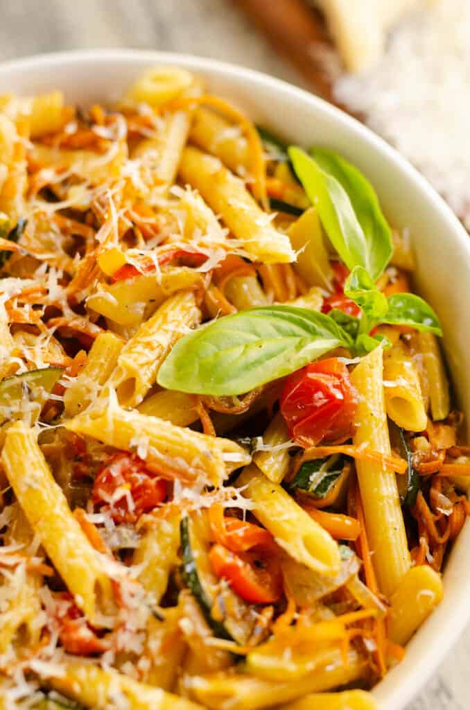 Pasta Primavera in white bowl with fresh basil and parmesan