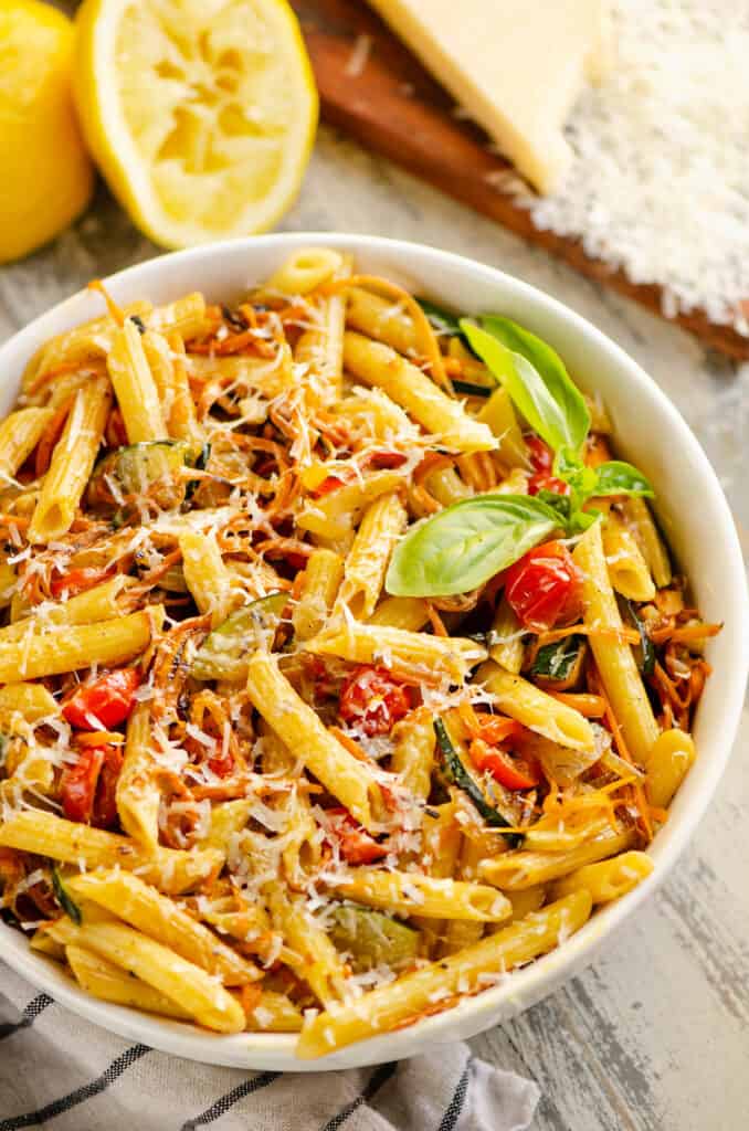 white bowl with Pasta Primavera topped with fresh basil