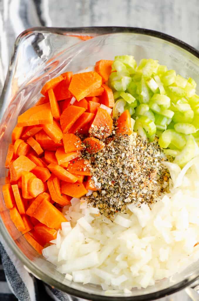 carrots, celery, onions and Greek Freak seasoning in bowl for chicken noodle soup