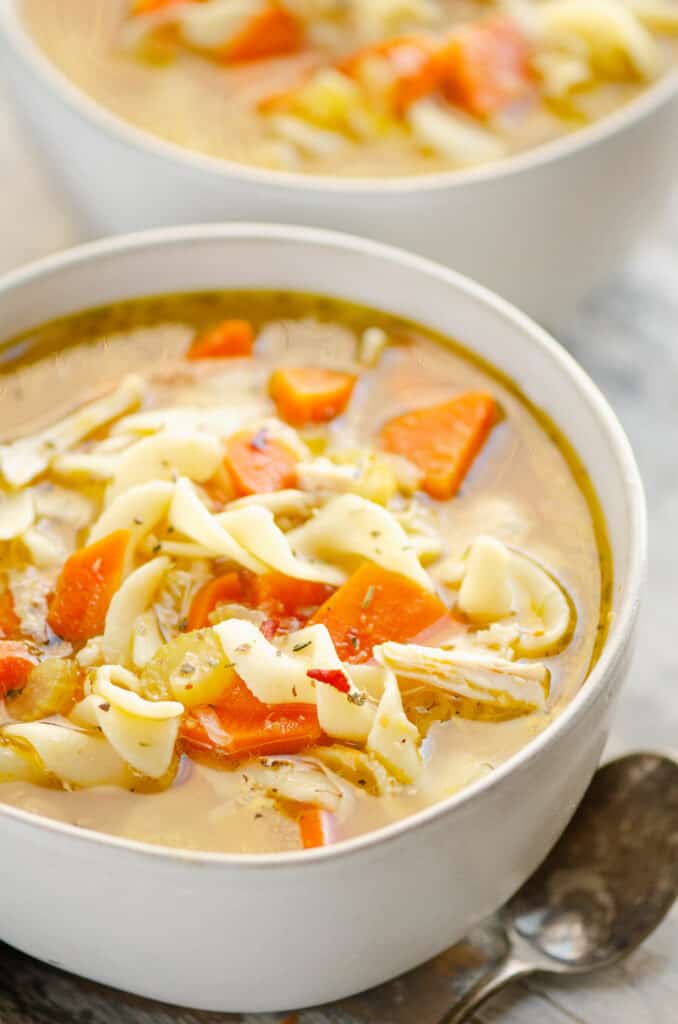 bowl of Greek chicken noodle soup in white bowl