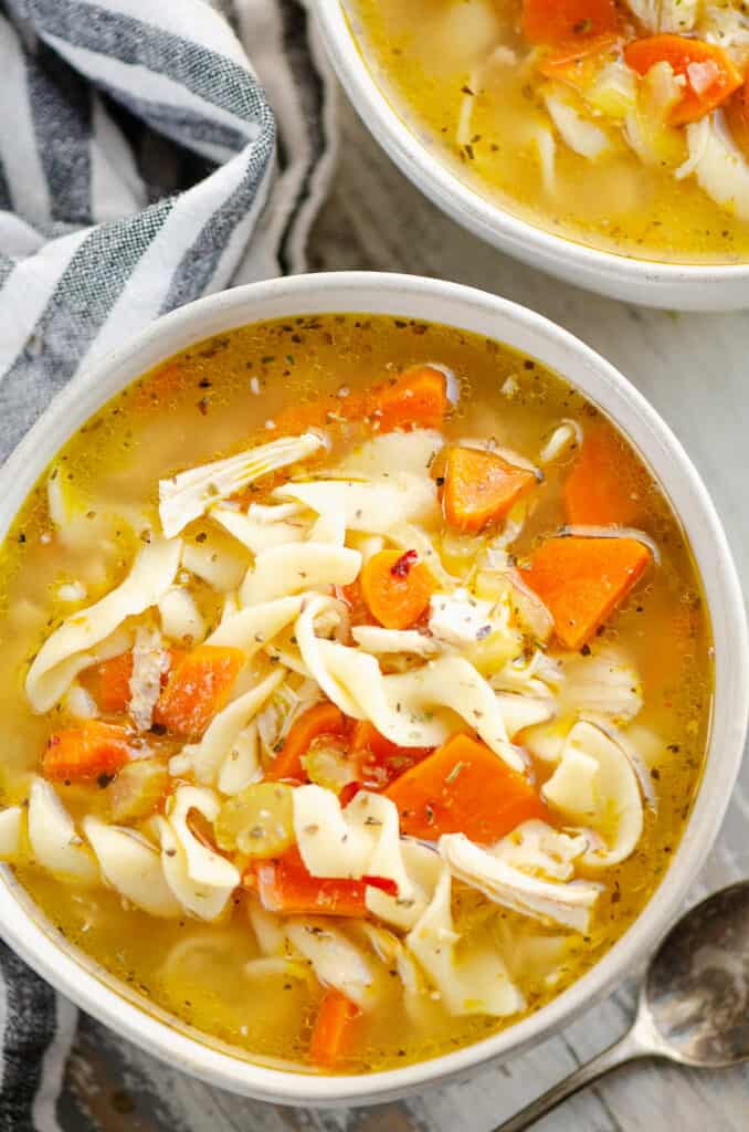 bowl of Greek chicken noodle soup in bowl with cloth napkin