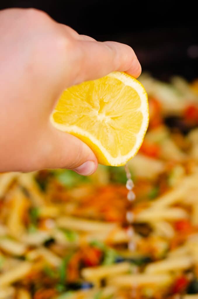 fresh lemon juice squeezed over Blackstone pasta primavera on griddle