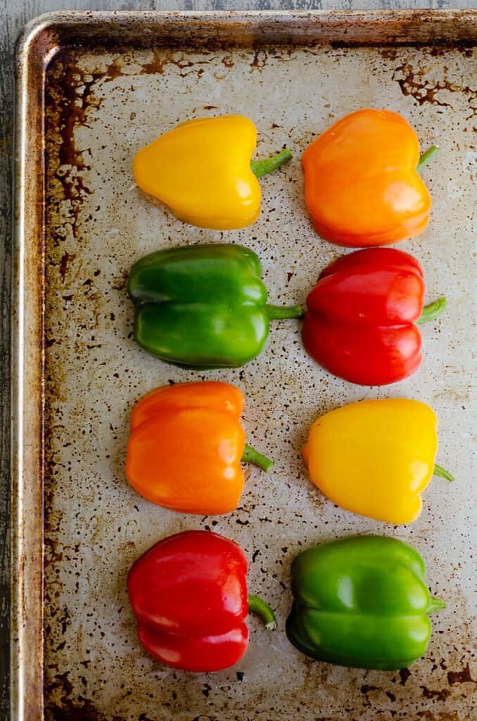 bell peppers sliced in half on baking sheet