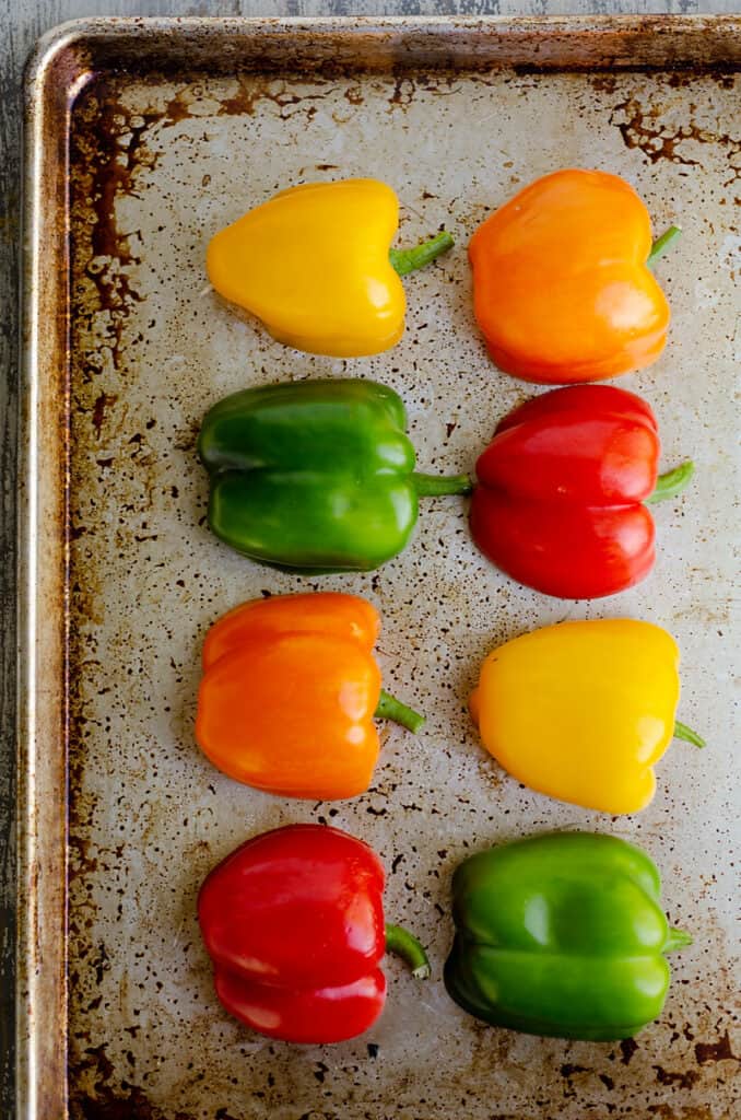 bell peppers sliced in half on baking sheet