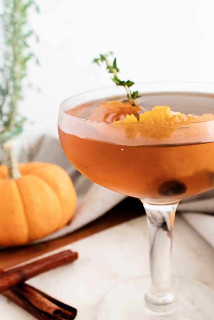 fall spiced old fashioned with orange peel and thyme in glass
