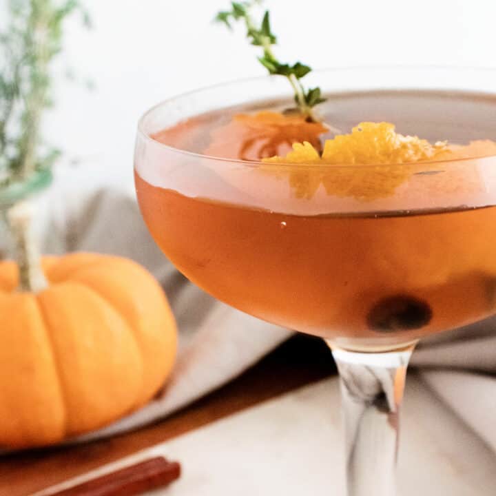 fall spiced old fashioned with orange peel and thyme in glass