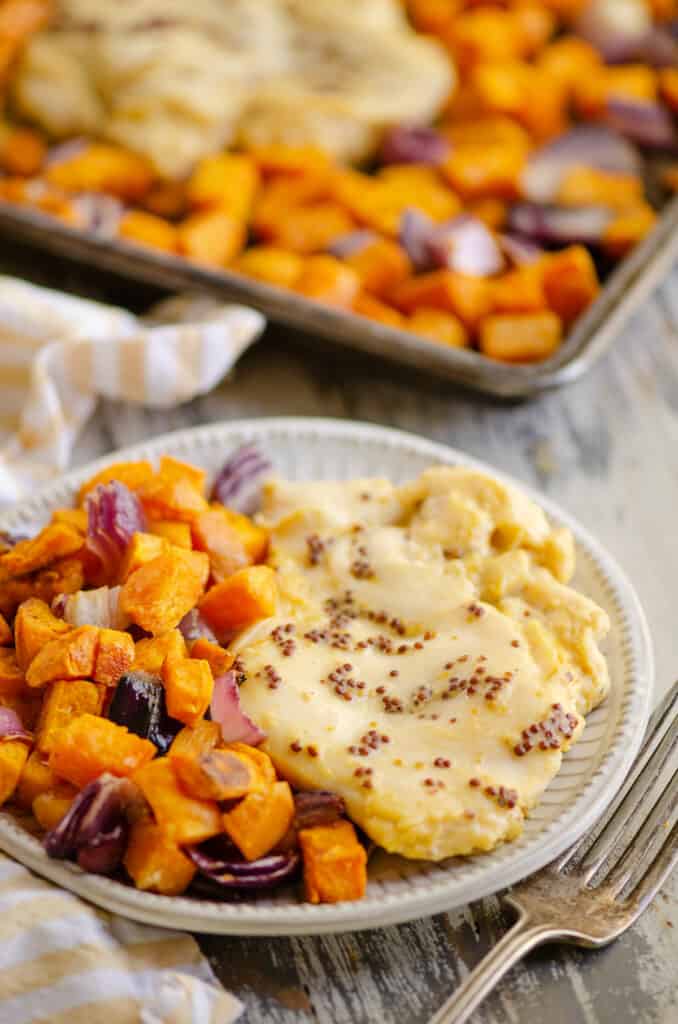 honey mustard chicken breast and roasted sweet potatoes on plate with fork