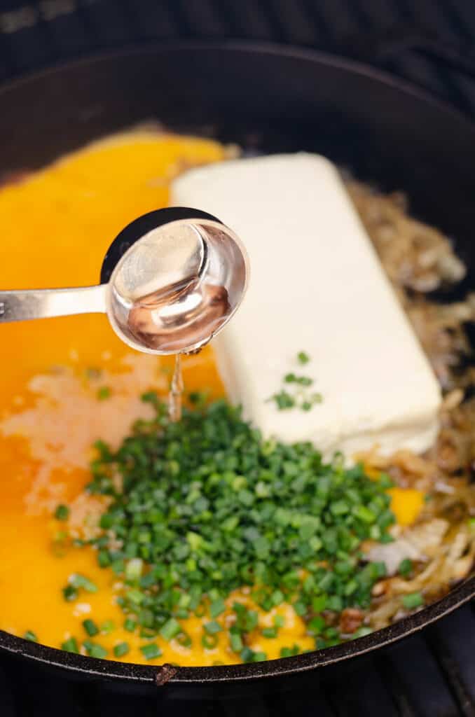 red wine vinegar poured into skillet with cream cheese, chives and cheddar