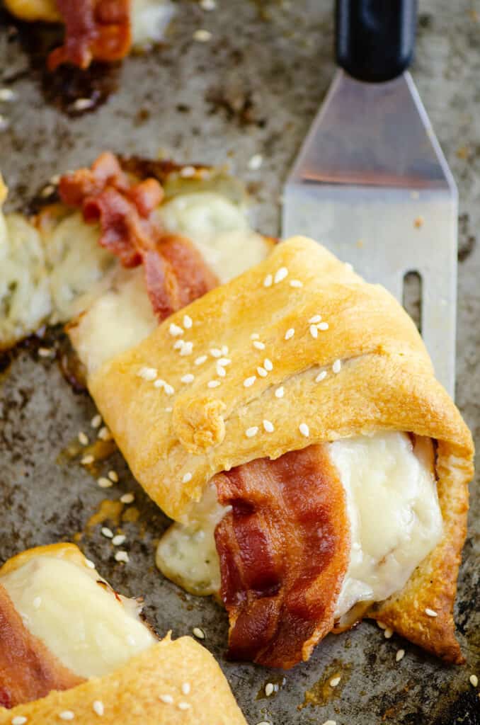 turkey bacon swiss crescent roll on pan with spatula