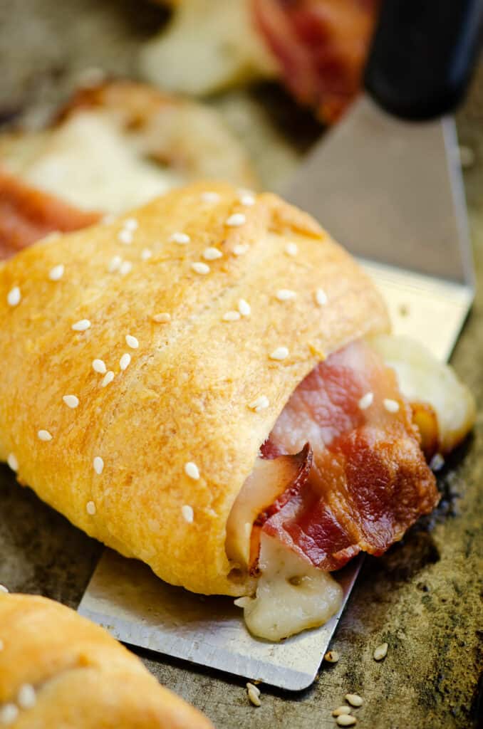 bacon swiss crescent roll topped with sesame seeds