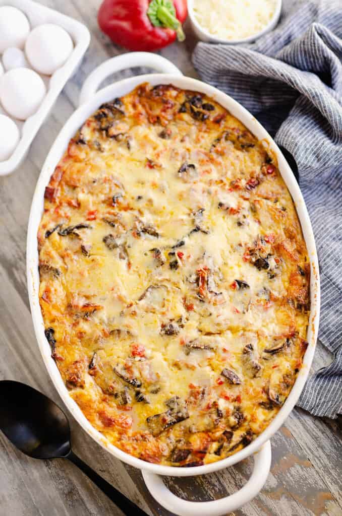 overnight ham and vegetable egg bake in white casserole on breakfast table