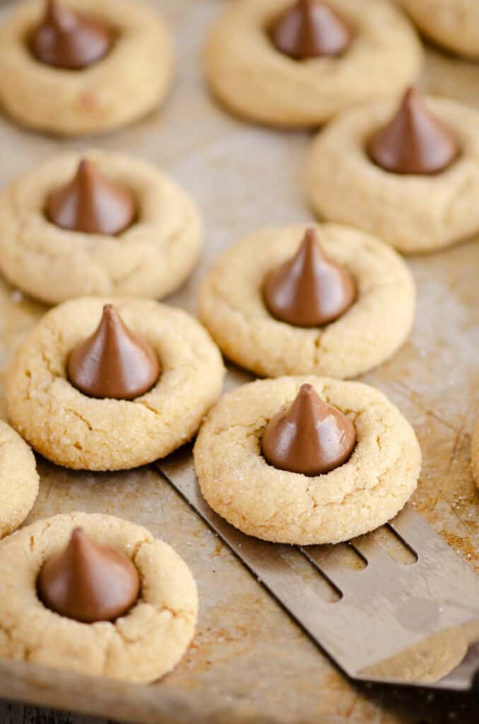 peanut butter blossom cookies on cookie sheet with spatula