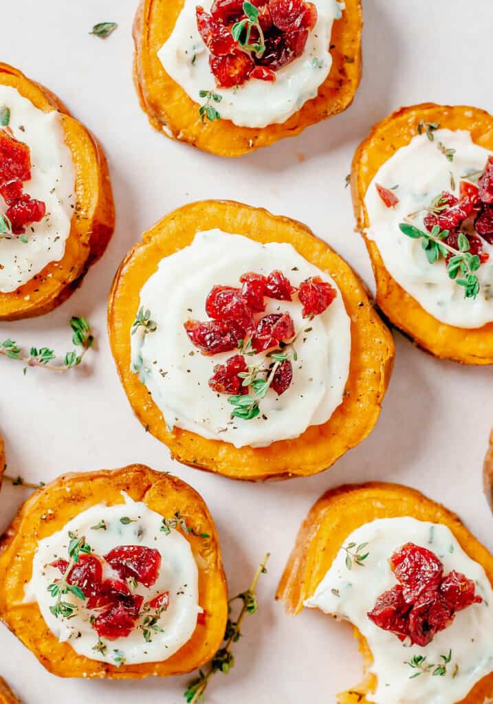 sweet potato bites on white tray topped with cranberries and thyme